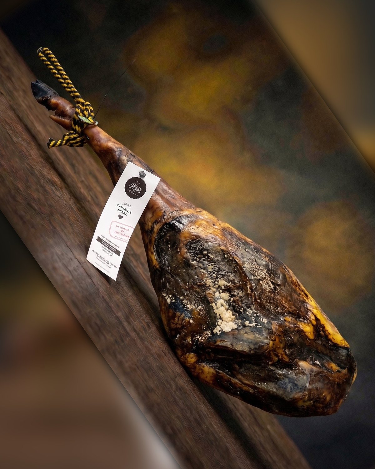 Pieza de jamón ibérico con etiqueta sobre tabla de madera
