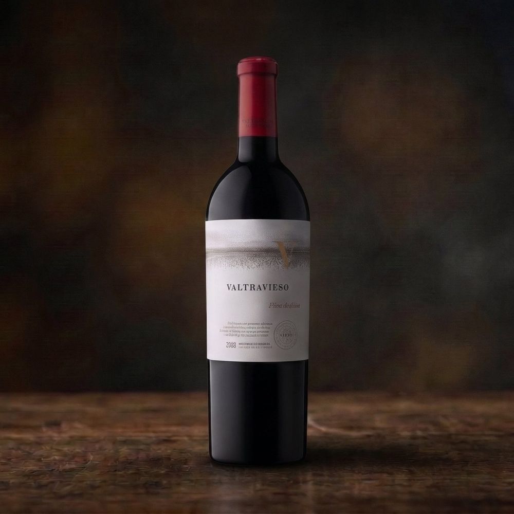 Botella de vino tinto Valtravieso sobre una mesa de madera